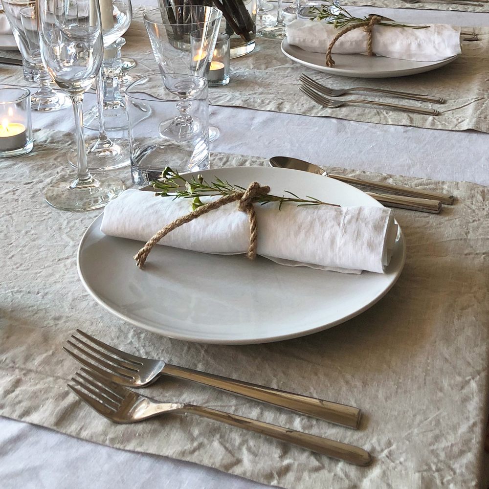 Scandinavian dinner party layering white and natural flax table linens