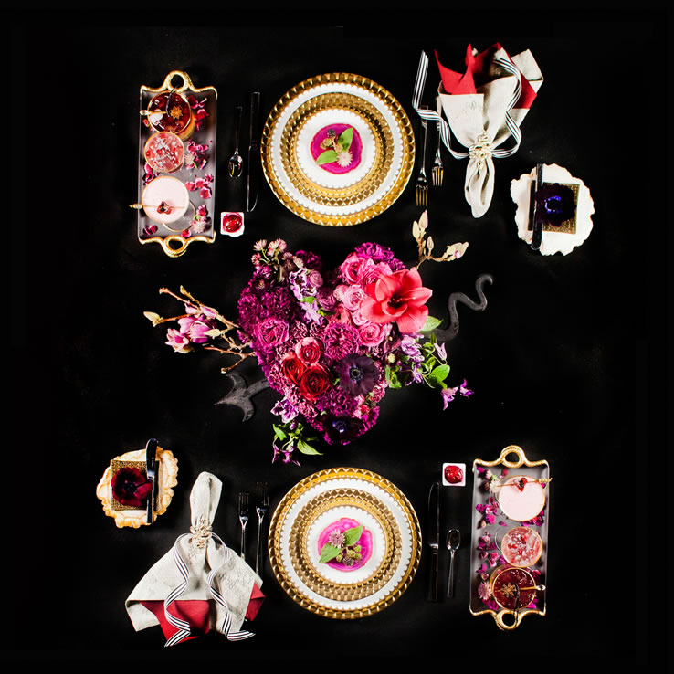 Decadent, romantic place setting featuring a heart-shaped floral display, gold-rimmed china and Huddleson Python print linen napkin layered with a rich deep red Claret solid colored linen napkin